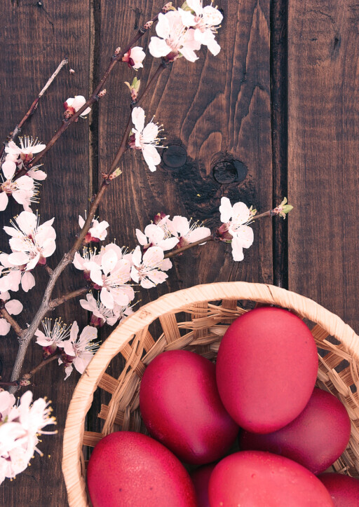 Basket With Easter Cake And Red Eggs On Rustic Wooden Table. Top