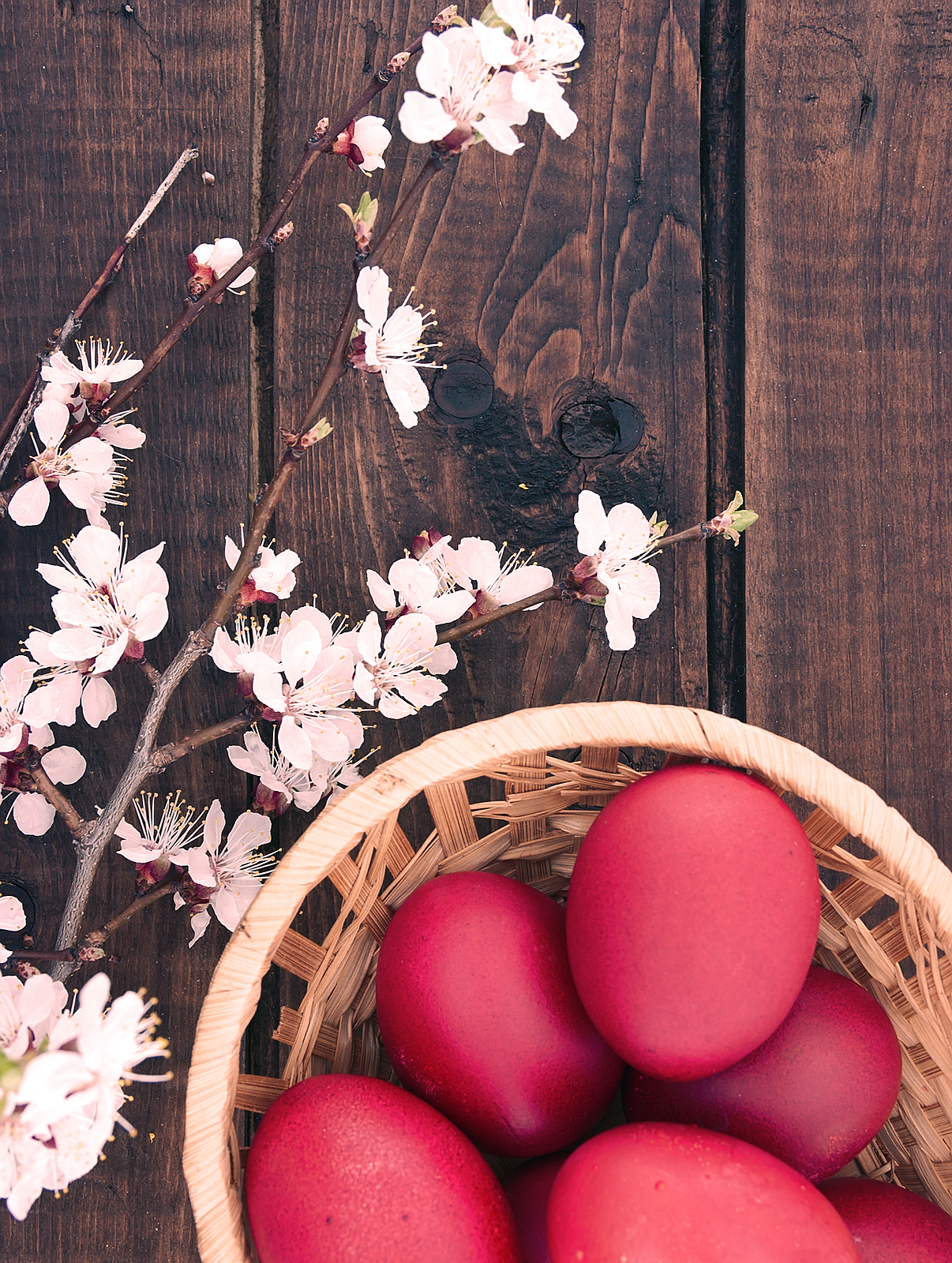 Basket With Easter Cake And Red Eggs On Rustic Wooden Table. Top
